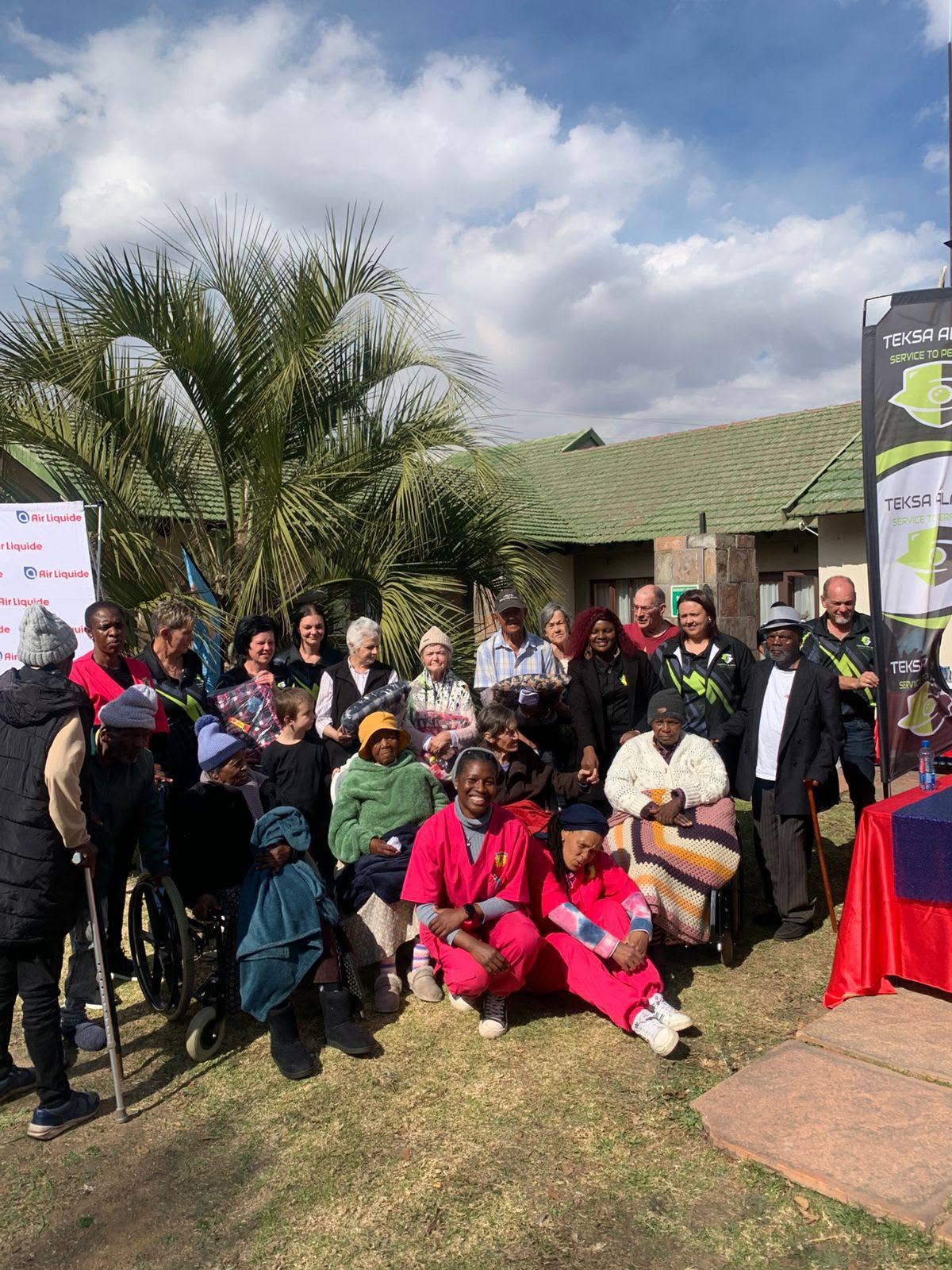 Teksa Alarms team with residents outdoors during a donation day